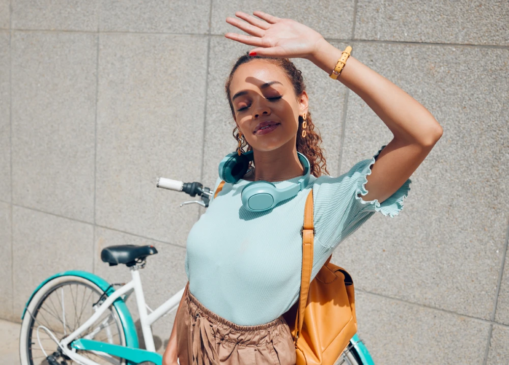 Woman outdoors protecting skin after Botox treatment.